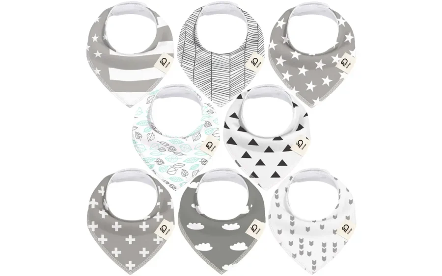 Selection includes grey star-stripes, herringbone weave, minimalist white stars, aqua leaves, geometric triangles, white crosses, dreamy grey clouds, and modern arrows. These highly absorbent 100% cotton bibs are purely handcrafted and guaranteed to pass international GOTS and OEKO-TEX certifications through our OEM, ODM, and Customized services.