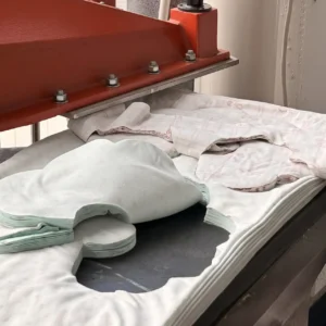 Precision Die-Cutting Process completion reveals perfectly formed bibs for baby blanks featuring precise silhouettes. Clean edges demonstrate superior cutting quality. Professional OEM/ODM manufacturing from Chinese B2B baby textile factory.