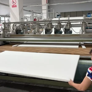 Our quality assurance workflow subjects each detached mattress core panel to a strict "three-dimensional verification" protocol right at the discharge conveyor. Our specialist handles the newly formed blocks manually to perform direct structural samplings for surface flatness, edge verticality, and core weight consistency.