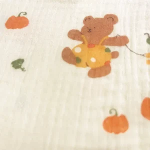 Charming detail showcasing the adorable teddy bear and pumpkin characters of Harvest Joy baby bibs. Precise print clarity and warm color palette create engaging visual appeal. OEM/ODM specialist—professional Chinese textile factory solutions.