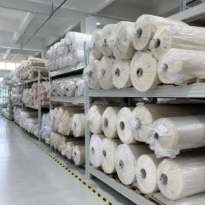 Our climate-controlled manufacturing warehouse securely stores thousands of sealed fabric rolls on heavy-duty industrial racking systems. As a streamlined baby textile factory in China, we enforce strict inventory management protocols to keep our premium textile reserves completely free from dust, moisture, and contamination.