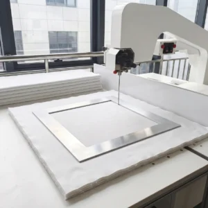 Our precision shaping process utilizes heavy-gauge steel frame templates to guide the mechanical cutting blade smoothly along exact dimensional perimeters. Operating as a tech-driven baby textile factory in China, we employ these specialized molds to strictly control the profile and final borders of our premium double-sided blankets.