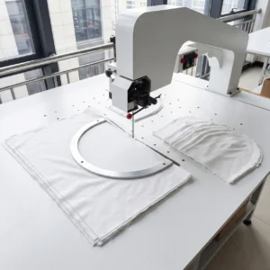Our specialized pre-cutting setup employs a curved metal template to form precise semi-circular shapes required for functional hooded styles. Our baby textile factory in China enforces strict accuracy guidelines across all cutting units to ensure consistent, smooth curves for infant outerwear.