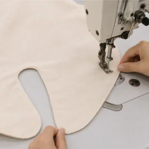 Our specialty assembly workflow involves high-strength structural stitching and reinforced binding around intricate leg openings and harness slots. Our baby textile factory in China utilizes manual machine assistance to guide complex curved contours flawlessly under the needle.