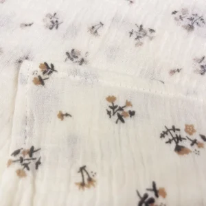 High-definition close-up reveals delicate botanical floral print and fine muslin weave texture. Precise print clarity demonstrates superior craftsmanship. Professional OEM/ODM services from Chinese B2B baby textile factory for premium muslin blankets.