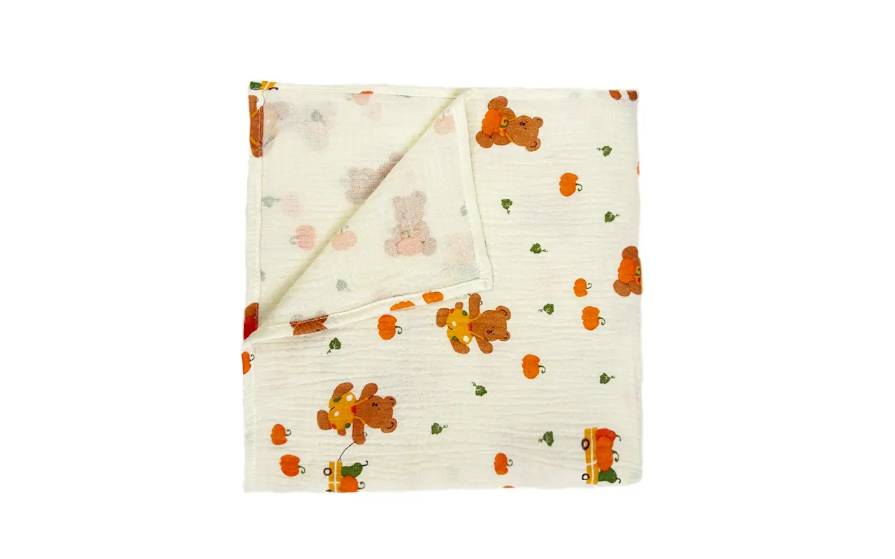 Neatly folded Harvest Joy muslin cotton blanket reveals complete size, premium fabric quality, and balanced bear and pumpkin print distribution. Versatile multi-use seasonal design. OEM/ODM wholesale from professional Chinese B2B textile factory.