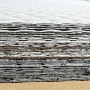 Cross-section view reveals sophisticated multi-layer composite structure combining padding, batting, and support fabrics. Professional layering ensures durability and optimal performance. OEM/ODM manufacturing from professional Chinese B2B baby textile factory.