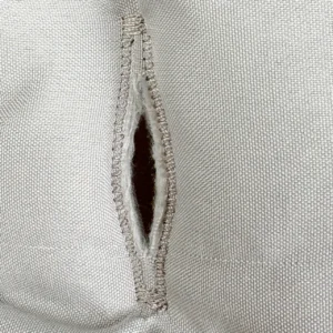 Our infant seat cushion core harness holes undergo a heavy-duty binding thread reinforcement process to lock the fabric layers tightly. As a specialized baby textile factory in China, we implement these dense industrial stitching standards to completely eliminate raw edge fraying during long-term operational use.