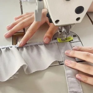 Our component installation phase precisely aligns the pre-fitted Velcro nylon straps onto the main cushion fabric edge containing the elastic band. Our baby textile factory in China utilizes skilled artisans to perform this rear-installation method, enhancing the overall professional layout of the structural seams.