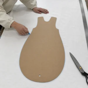 Our manual pattern nesting phase utilizes a customized template layout to map out the exact cutting boundary lines with precision tailor's chalk on raw cotton fabric. Our baby textile factory in China enforces tight nesting strategies on clean cutting tables to significantly minimize raw material waste.