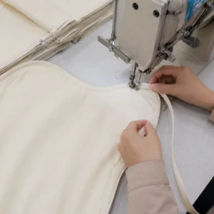 Our final edge-processing utilizes a hand-assisted binding technique to apply fine-edge locking around critical areas like curves, armholes, and necklines. As a quality-driven baby textile factory in China, we implement these precise trim application steps to deliver rounded, full, and supple borders.