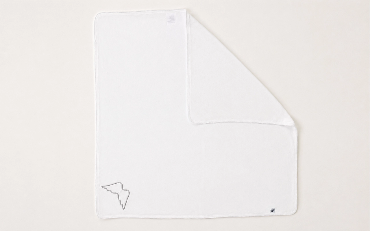 Our B2B custom cotton baby blanket features a soft 100% cotton knit, a white merrow edge, angel-wing applique, and logo label, made by our Hangzhou, China OEM/ODM factory with 40+ years of experience.