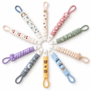 Our radial display presents ten full polyester baby pacifier clips with gathered elastic straps, secure PU plastic fasteners, and soft attachment loops in varied colors, prints, and decorative themes.